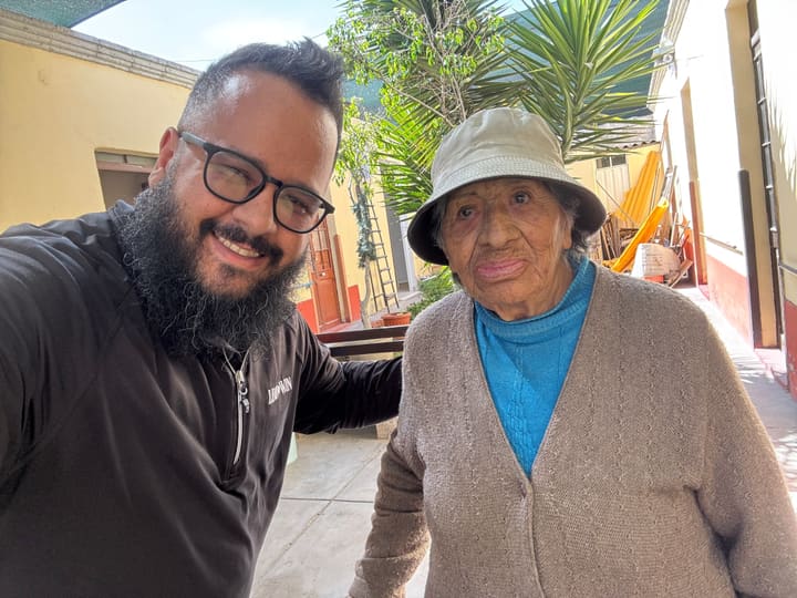 Chaplain taking a selfie with an elderly woman in a residential courtyard